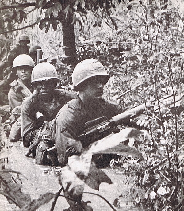 Vietnam War - First Infantry Division.  Soldiers wade through swamp