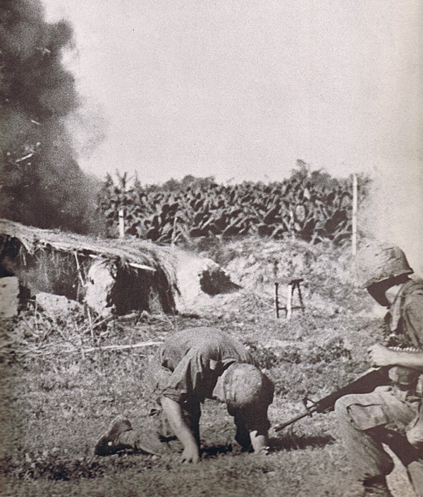 First Infantry Division soldiers take cover from an explosion during the Vietnam War.  Photo Courtesy of First Infantry Division. 