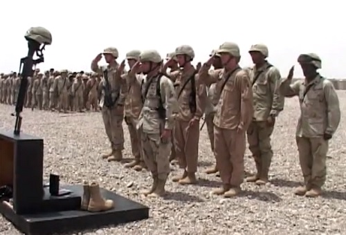 Soldiers of the 42nd Infantry Division, New York National Guard, pay respects to a fallen comrade at a memorial service in Iraq.  